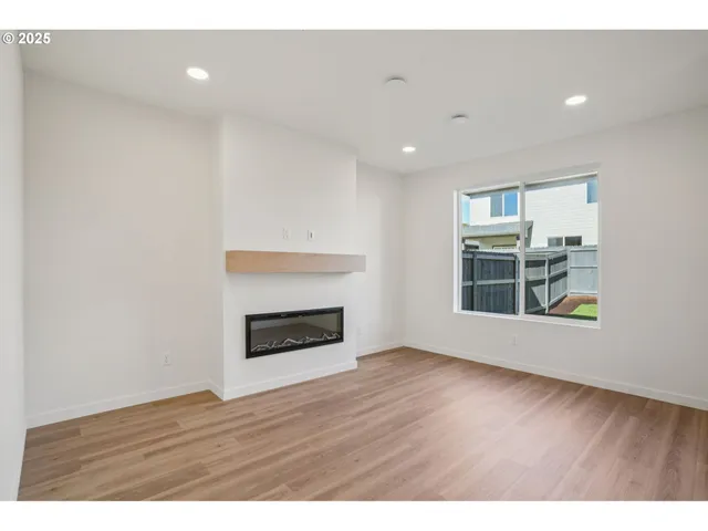 a view of wooden floor fire place and windows in a room