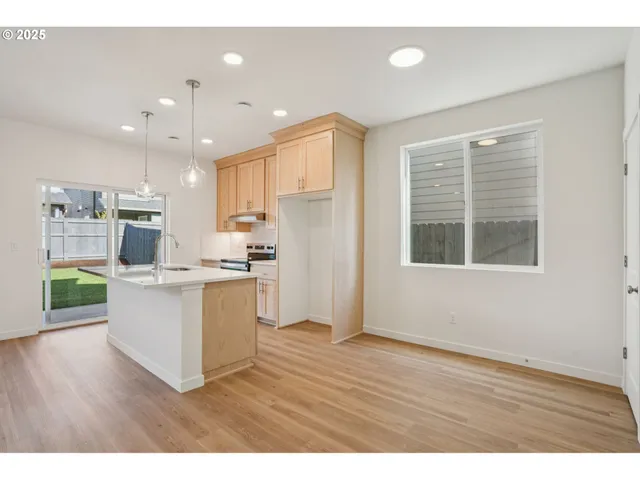 a kitchen with a refrigerator and a wooden cabinets