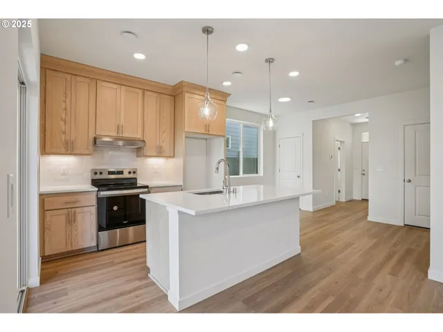 a kitchen with kitchen island granite countertop a sink cabinets and stainless steel appliances