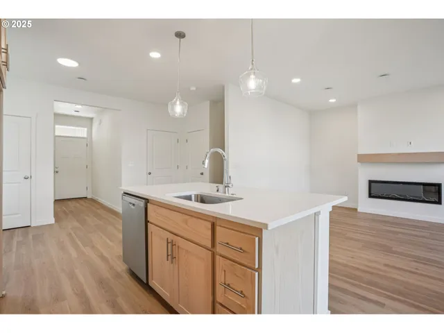a kitchen with a sink cabinets and wooden floor