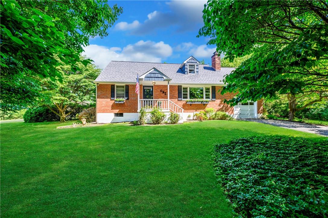 a front view of a house with a garden and trees