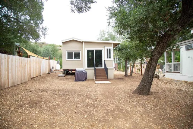 a view of a house with backyard and a tree
