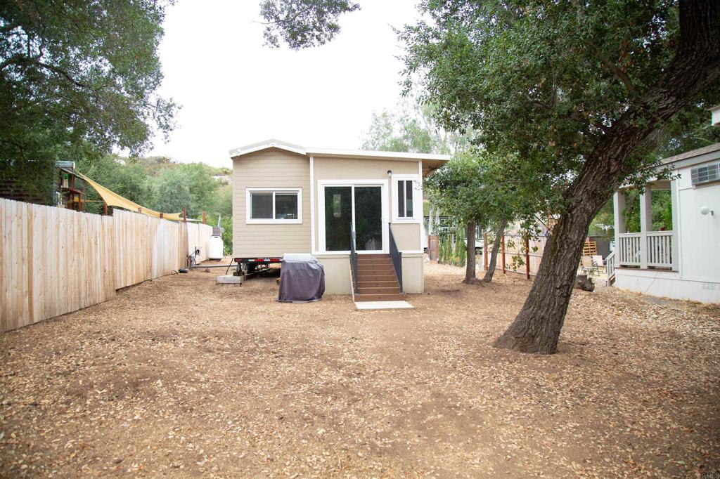 14625 Mussey Grade Road, Unit R67 Ramona, CA 92065 - Photo 19 of 31 a view of a house with backyard and a tree
