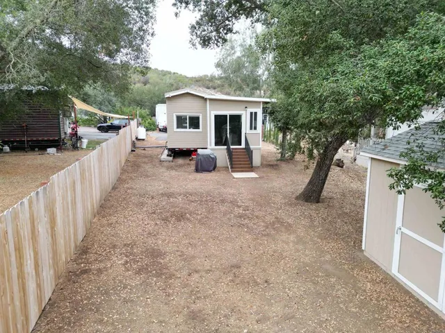 a view of a house with backyard and sitting area