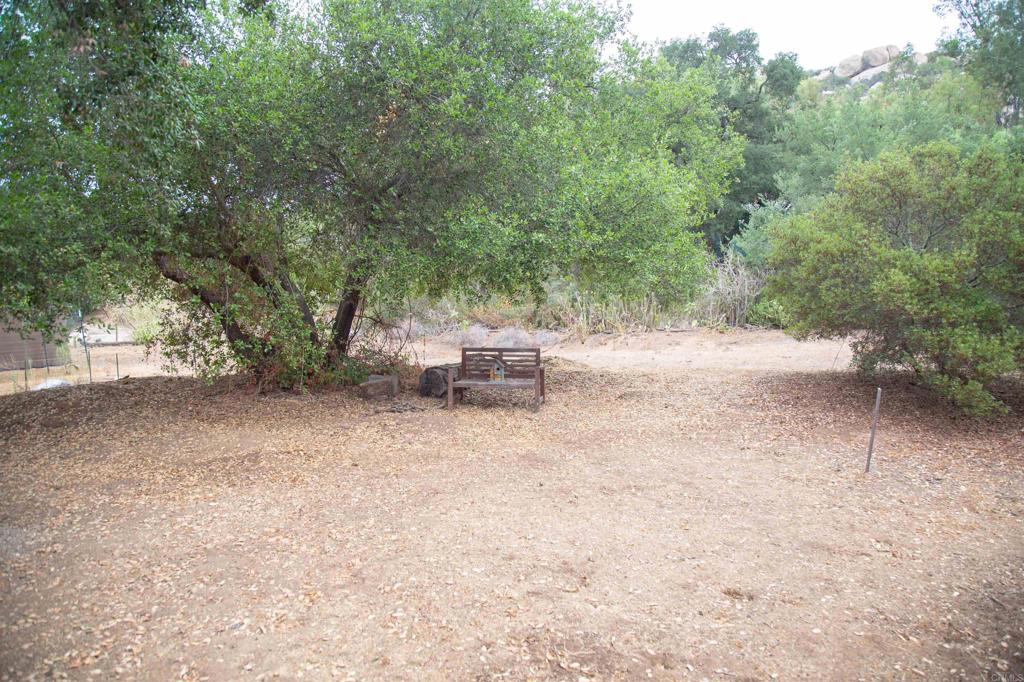 14625 Mussey Grade Road, Unit R67 Ramona, CA 92065 - Photo 28 of 31 a backyard of a house with a fountain and large trees