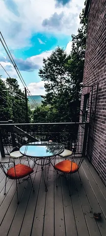 a view of a roof deck with table and chairs