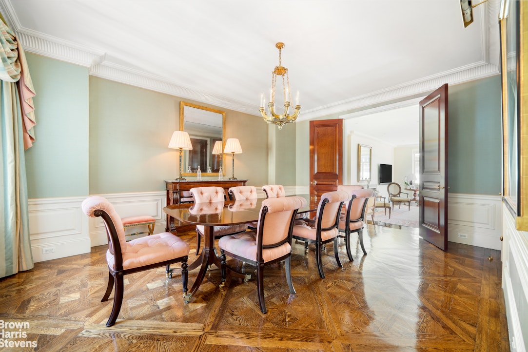 a dining room with furniture a chandelier and wooden floor