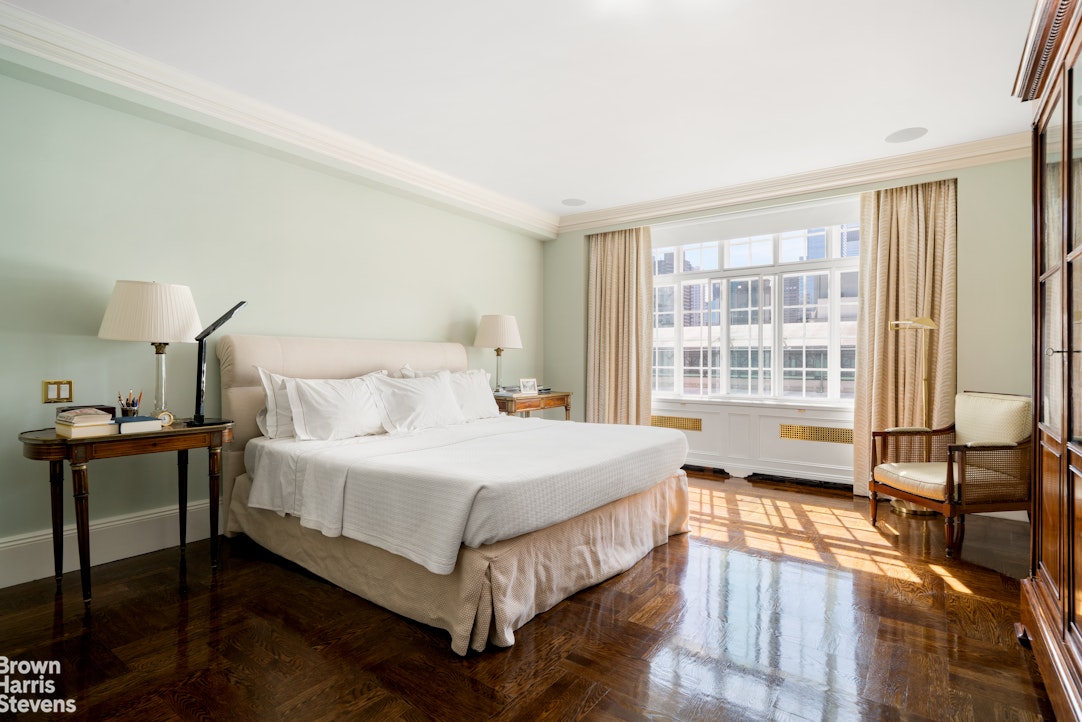 116 East 68th Street, Unit 7/8D Manhattan, NY 10065 - Photo 8 of 14 a bedroom with a bed and wooden floor