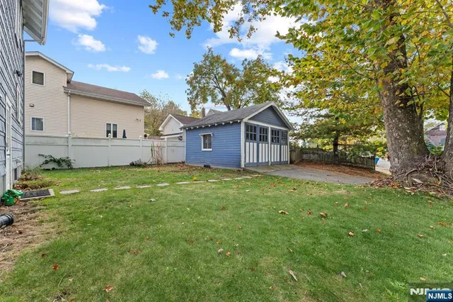 a view of a house with a big yard and large tree