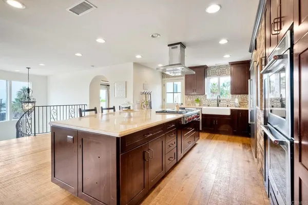 a large kitchen with stainless steel appliances granite countertop a large center island and a wooden cabinets