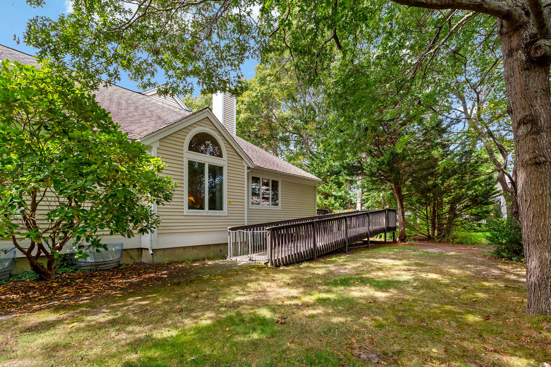 6 Friendship Court Mashpee, MA 02649 - Photo 22 of 39 a view of a house with a large tree and a yard