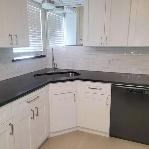 a kitchen with white cabinets and a sink