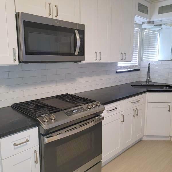 3459 Monte Carlo Street Dallas, TX 75224 - Photo 20 of 23 a kitchen with granite countertop white cabinets stainless steel appliances and sink