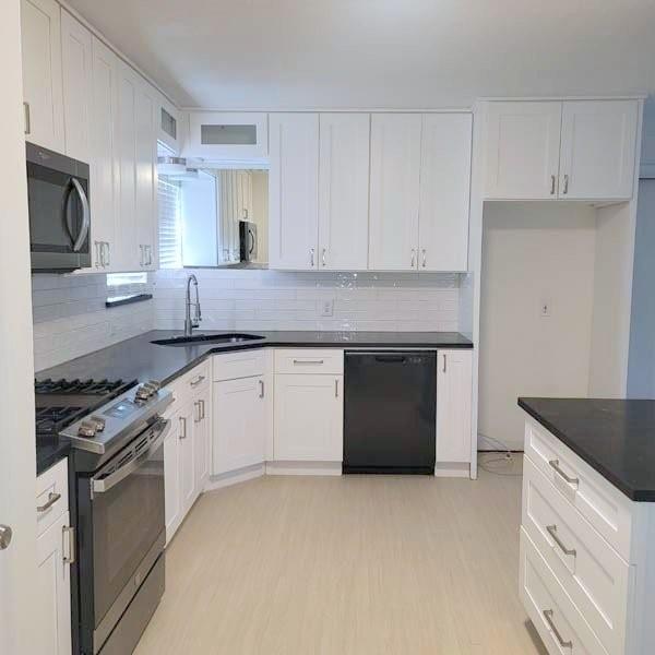 3459 Monte Carlo Street Dallas, TX 75224 - Photo 21 of 23 a kitchen with granite countertop white cabinets and stainless steel appliances