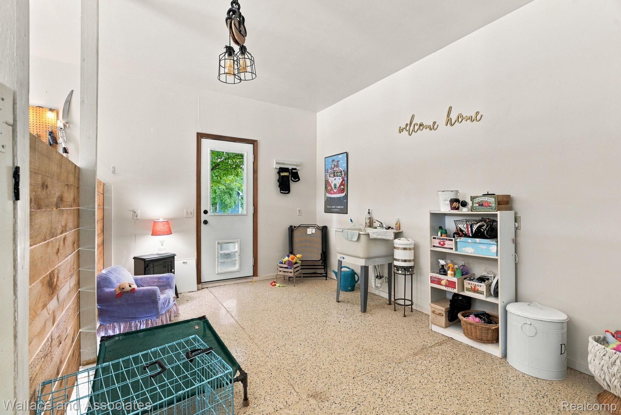 17076 27 Mile Road Ray, MI 48096 - Photo 56 of 63 Terrazzo-style flooring, white walls, wood-finish accent wall, ceiling-mounted light fixture, and a utility sink