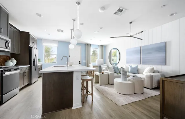 a large kitchen with kitchen island a large counter space a sink stainless steel appliances and cabinets