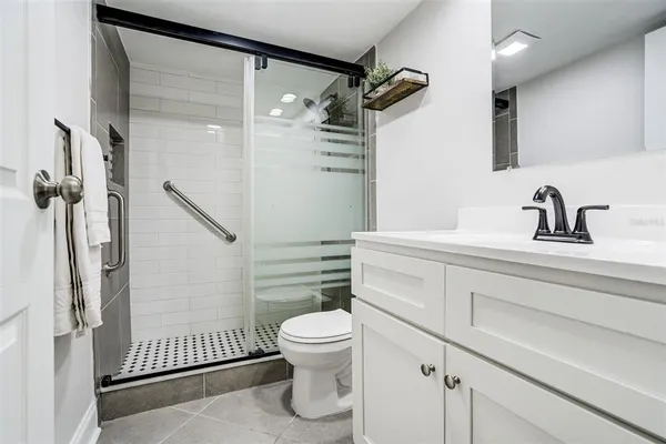 a bathroom with a sink a toilet and shower