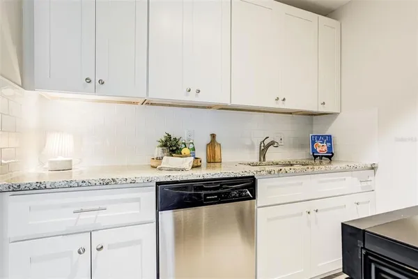 a kitchen with granite countertop white cabinets and a white appliances