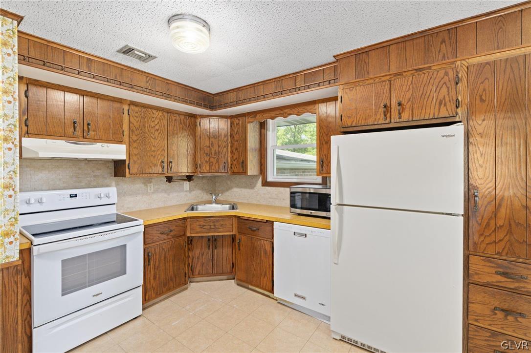 128 7th Street Whitehall, PA 18052 - Photo 9 of 29 a kitchen with a refrigerator sink stove and cabinets