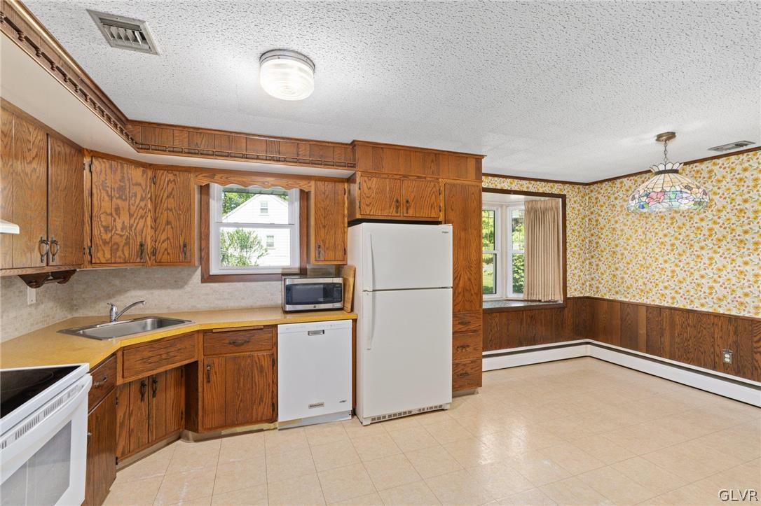 128 7th Street Whitehall, PA 18052 - Photo 10 of 29 a kitchen with a refrigerator a sink and a stove top oven