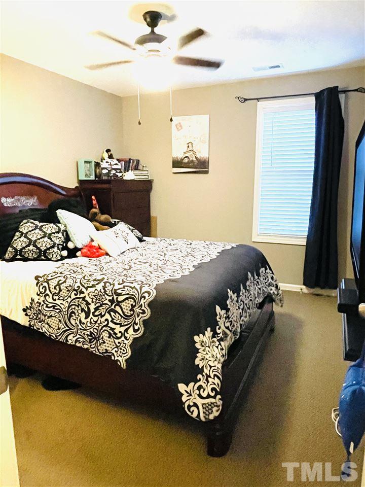 1368 Regulator Street Raleigh, NC 27603 - Photo 12 of 18 a bed sitting in a bedroom next to a window with tv and couch