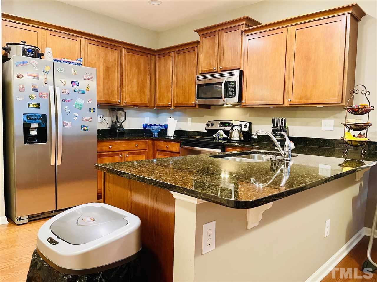 1368 Regulator Street Raleigh, NC 27603 - Photo 7 of 18 a kitchen with a sink a stove and a microwave