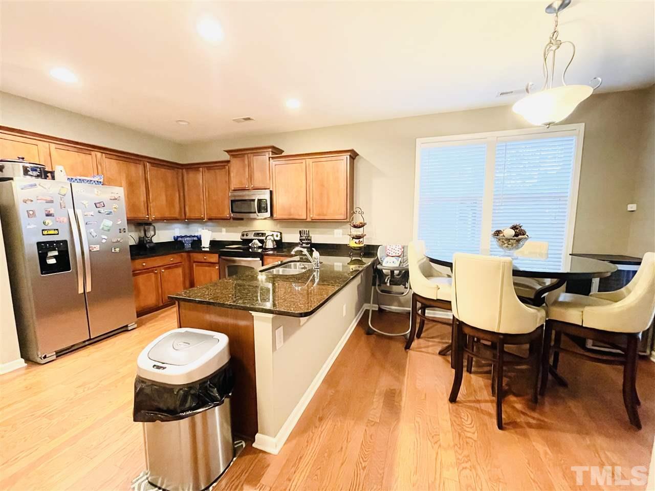 1368 Regulator Street Raleigh, NC 27603 - Photo 8 of 18 a kitchen with stainless steel appliances granite countertop a sink a stove and a refrigerator