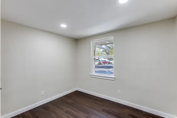 an empty room with wooden floor and a window