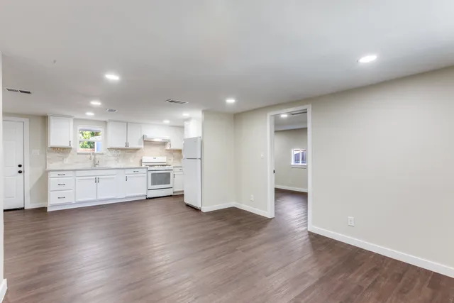 a view of a kitchen with wooden floor and a sink