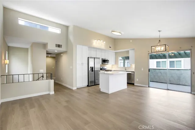 a view of kitchen with white cabinets and refrigerator