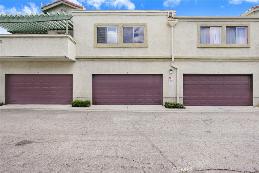 8353 Sunset Trail Place, Unit E Rancho Cucamonga, CA 91730 - Photo 13 of 18 a front view of a house with a yard and garage