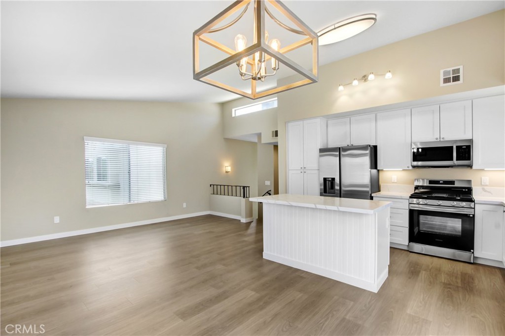 8353 Sunset Trail Place, Unit E Rancho Cucamonga, CA 91730 - Photo 2 of 18 a kitchen with kitchen island a stove a sink and a microwave