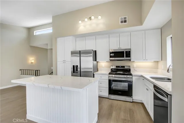 a kitchen with stainless steel appliances a stove sink microwave and cabinets