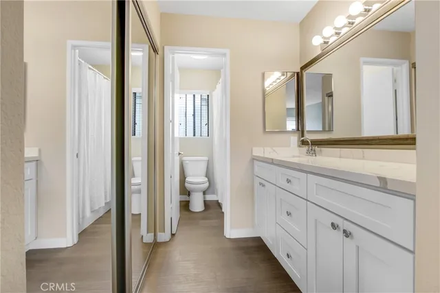 a spacious bathroom with a granite countertop sink mirror and a toilet