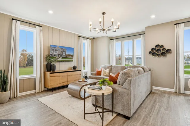 a living room with furniture a chandelier and a large window