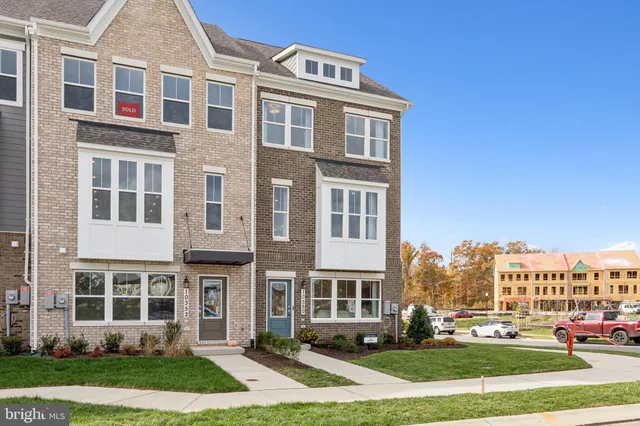 a front view of a residential apartment building with a yard