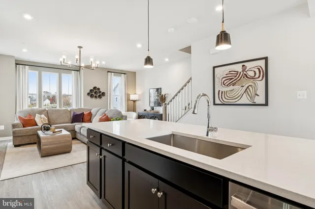 a hall with kitchen island a sink and a large window