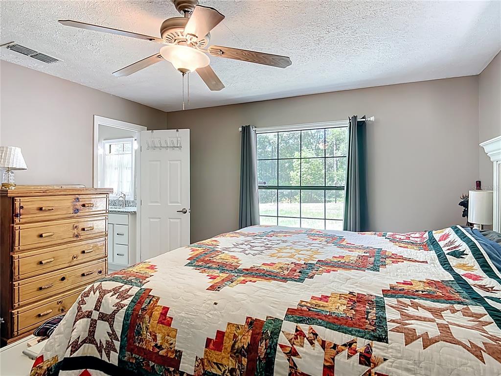 45 Forest Lane Bronson, FL 32621 - Photo 11 of 22 a bedroom with a bed and a chandelier