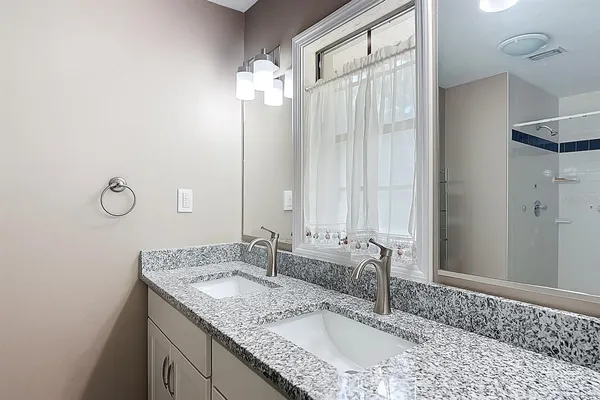 a bathroom with a granite countertop sink and a mirror