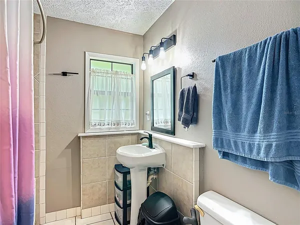 a bathroom with a sink a toilet and mirror