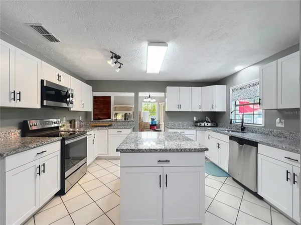 a kitchen with white cabinets appliances and a sink