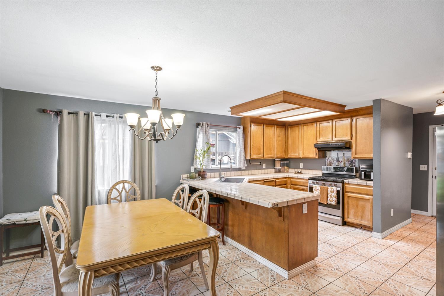 1755 3rd Street Lincoln, CA 95648 - Photo 6 of 22 a kitchen with a stove a sink a dining table and chairs