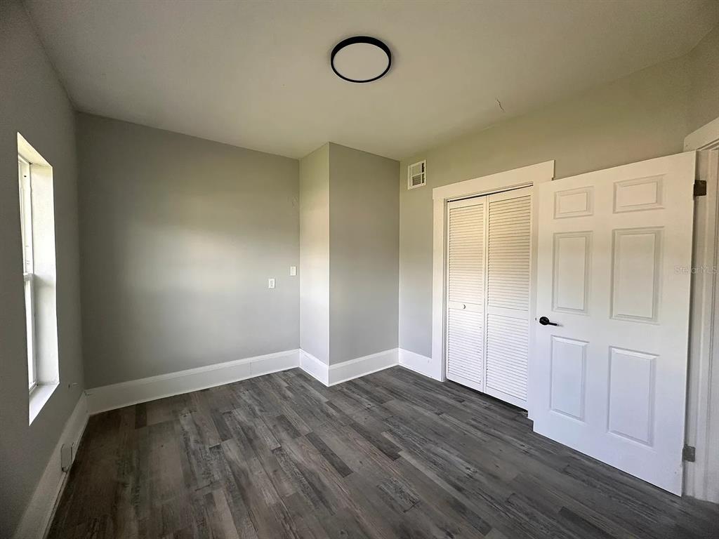 107 Ave F Southwest Winter Haven, FL 33880 - Photo 11 of 21 an empty room with wooden floor and window
