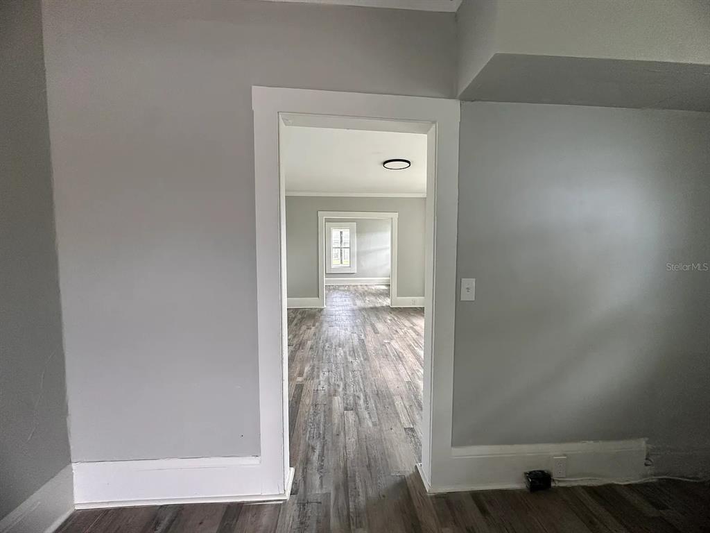 107 Ave F Southwest Winter Haven, FL 33880 - Photo 15 of 21 a view of a hallway with wooden floor and a livingroom