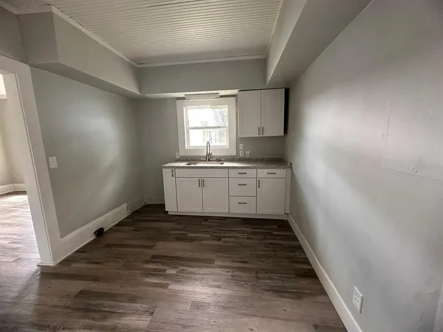 a kitchen with sink cabinets and wooden floor