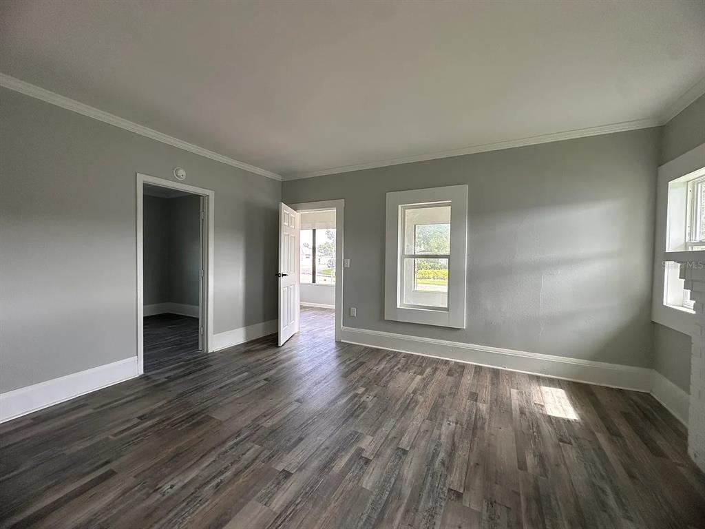 107 Ave F Southwest Winter Haven, FL 33880 - Photo 5 of 21 an empty room with wooden floor and windows
