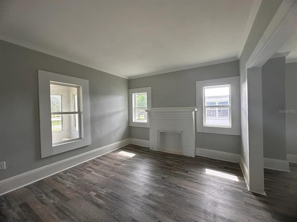 107 Ave F Southwest Winter Haven, FL 33880 - Photo 6 of 21 an empty room with wooden floor and windows