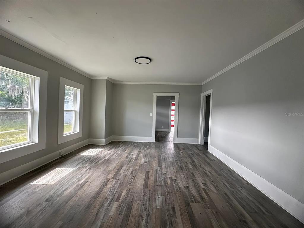 107 Ave F Southwest Winter Haven, FL 33880 - Photo 9 of 21 a view of an empty room with wooden floor and a window