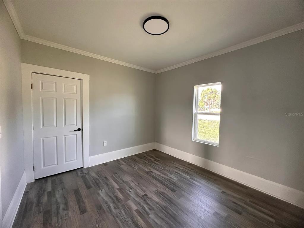 107 Ave F Southwest Winter Haven, FL 33880 - Photo 10 of 21 an empty room with wooden floor and window