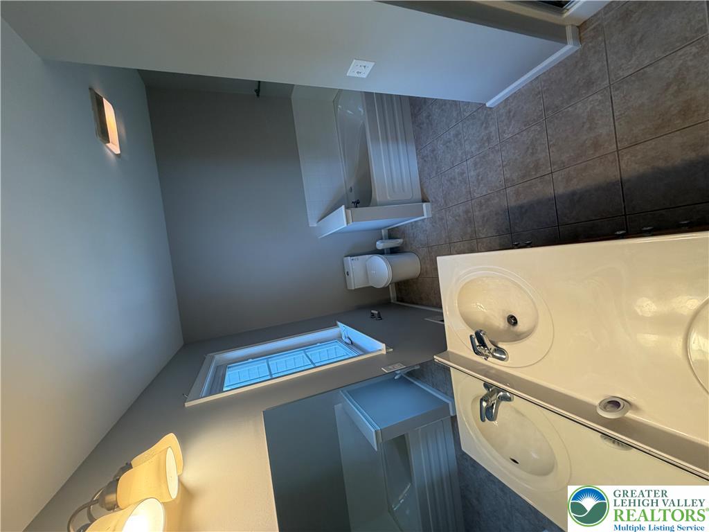 4157 Walter Road Bethlehem, PA 18020 - Photo 19 of 36 Well-lit primary bathroom featuring a dual vanity and a built-in tub.